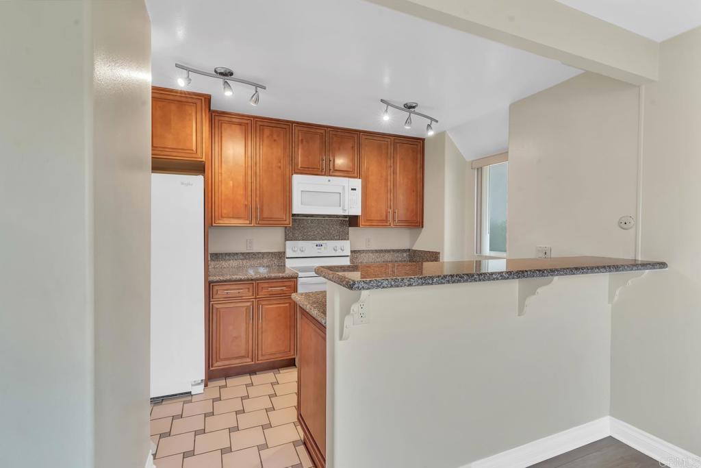 8636 Via Mallorca, Unit A La Jolla, CA 92037 - Photo 5 of 21 a kitchen with stainless steel appliances granite countertop a sink and a refrigerator