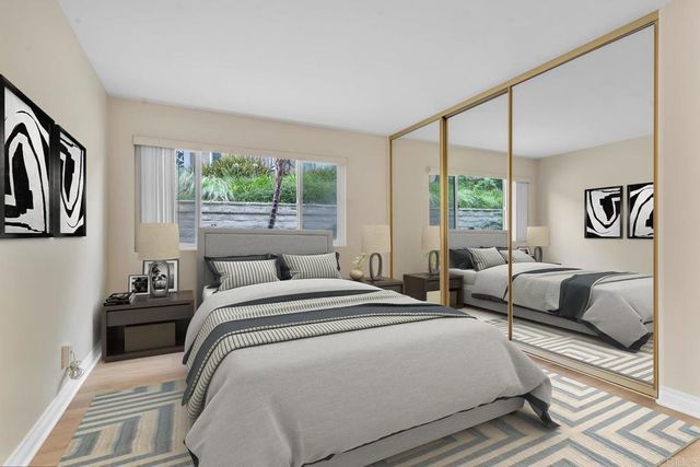 a bedroom with a bed couch and a large window