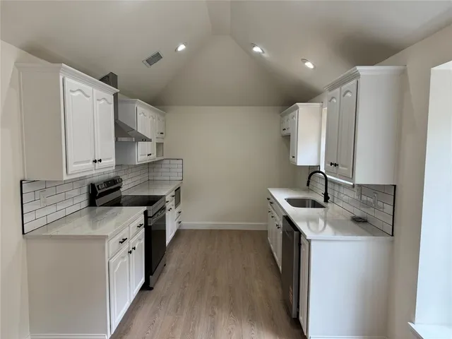 a kitchen with stainless steel appliances granite countertop a sink stove and refrigerator