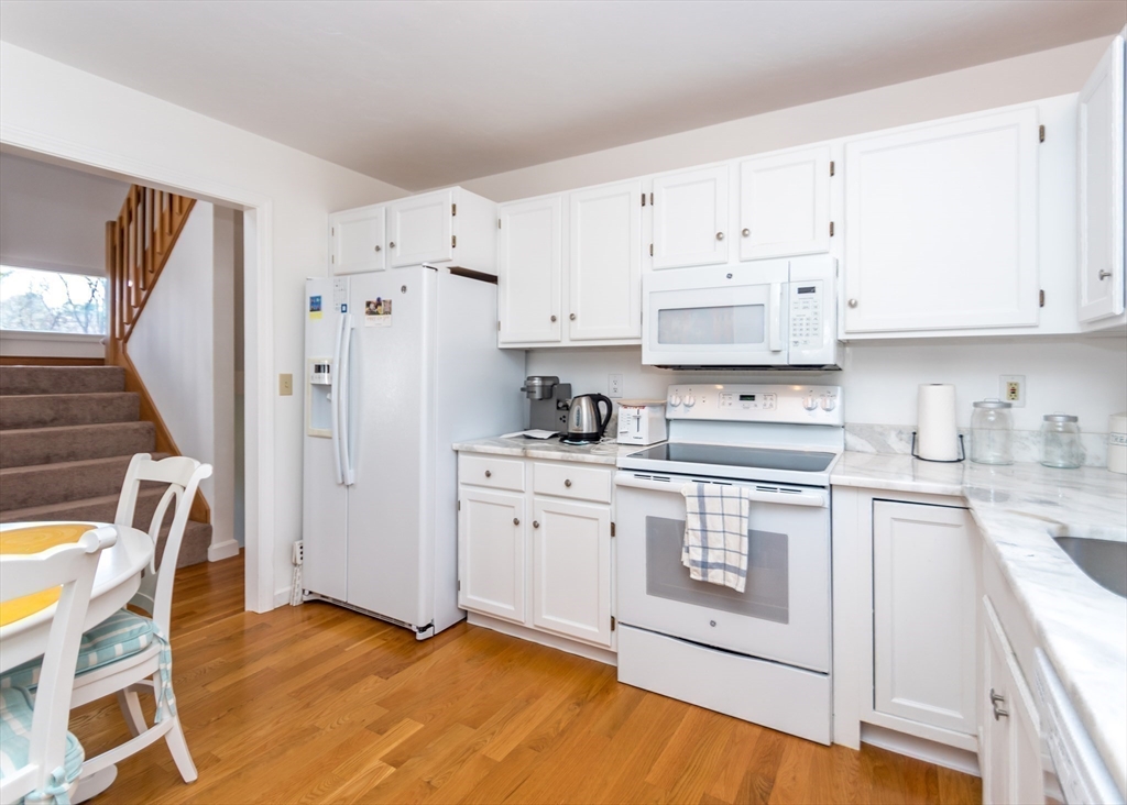 46 Timberline Road Millis, MA 02054 - Photo 13 of 38 a kitchen with stainless steel appliances white cabinets and wooden floors