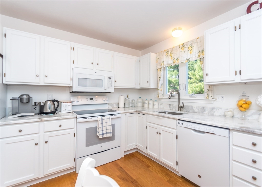 46 Timberline Road Millis, MA 02054 - Photo 10 of 38 a kitchen with granite countertop white cabinets white appliances and sink