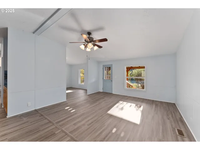 a large kitchen with cabinets wooden floor and stainless steel appliances