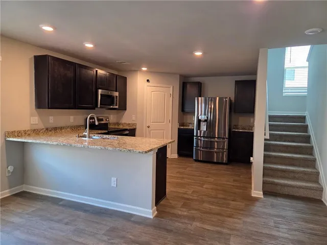 a kitchen with stainless steel appliances granite countertop a refrigerator and a stove top oven