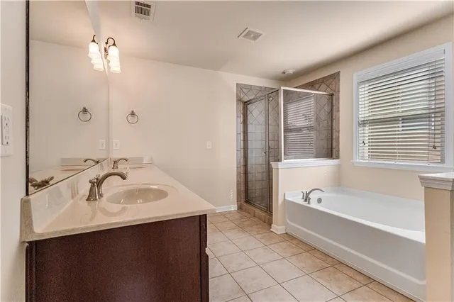 a spacious bathroom with a tub sink and mirror