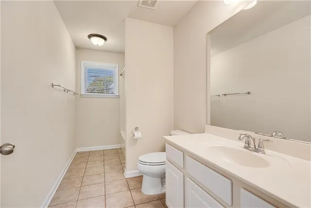 a view of a hallway with a livingroom and a bathroom with sink