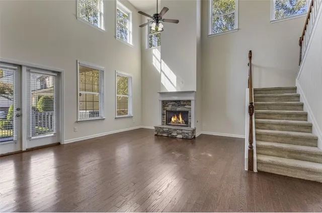 a view of an empty room with wooden floor fireplace and a window