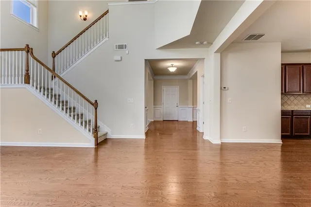 a view of a hallway with wooden floor and staircase
