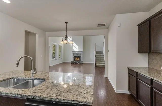 a kitchen with granite countertop a sink a counter top space appliances and cabinets