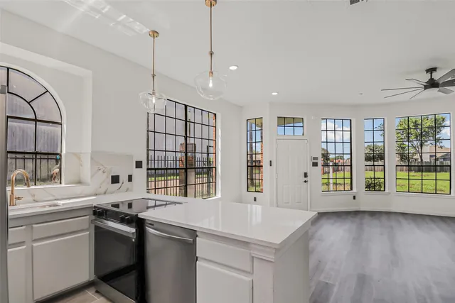 a kitchen with stainless steel appliances granite countertop a sink stove and wooden floor