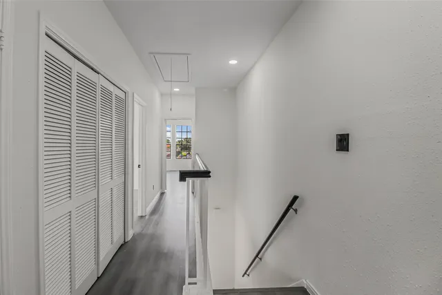 a view of a hallway with a white walls and stairs