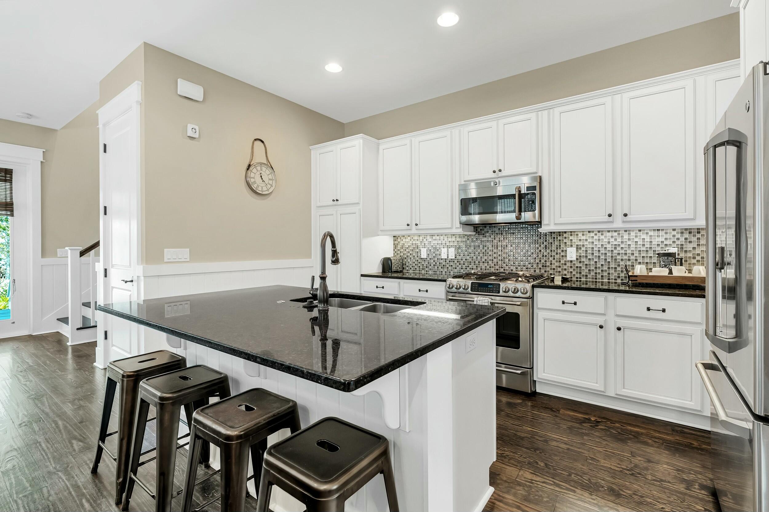 673 Flatwoods Forest Loop Santa Rosa Beach, FL 32459 - Photo 8 of 41 a kitchen with stainless steel appliances granite countertop a sink a stove and white cabinets