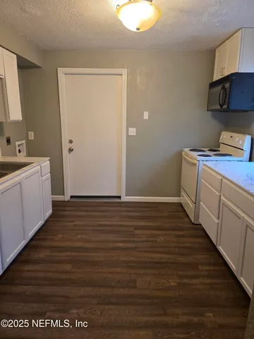 a view of a kitchen with wooden floor and a sink