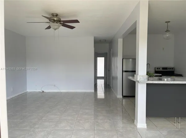 a view of an empty room with cabinet and a window