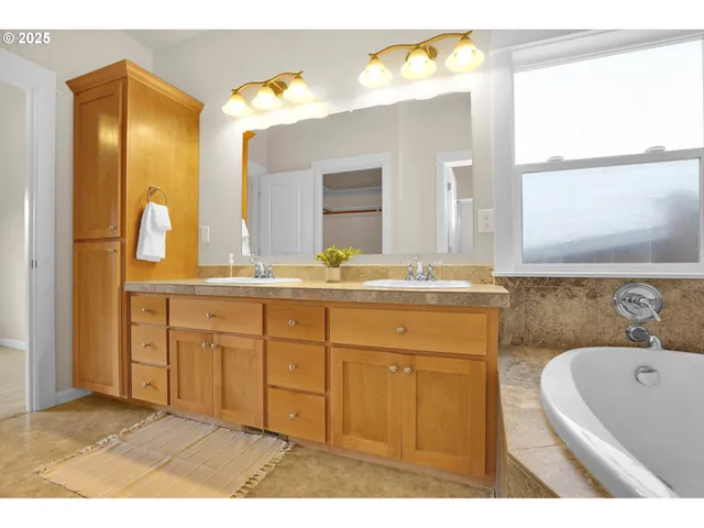 a bathroom with a granite countertop sink mirror and a bathtub