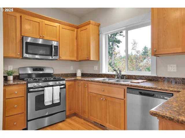 a kitchen with stainless steel appliances granite countertop a stove microwave and sink