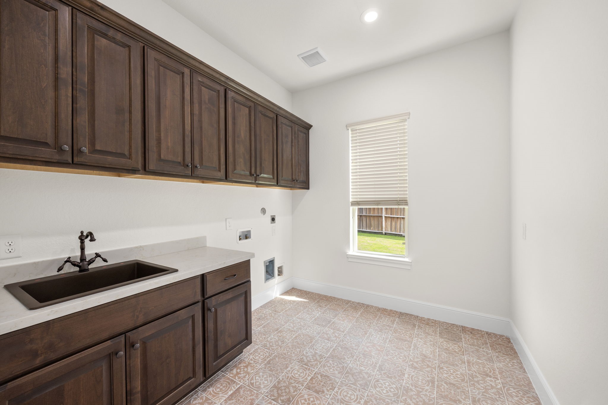 8551 Tombron Grove Road Magnolia, TX 77354 - Photo 43 of 49 The spacious laundry room is thoughtfully designed to combine everyday functionality with upscale style. Featuring abundant cabinetry and counterspace, this well organized utility area makes household task efficient. Beautiful custom tile flooring and ample storage and room for full sized appliances ensure the space is as practical as it is polished.