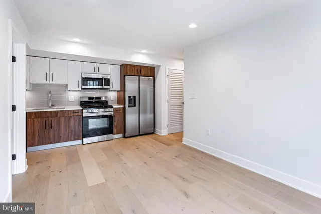 a kitchen with stainless steel appliances granite countertop a refrigerator and a sink