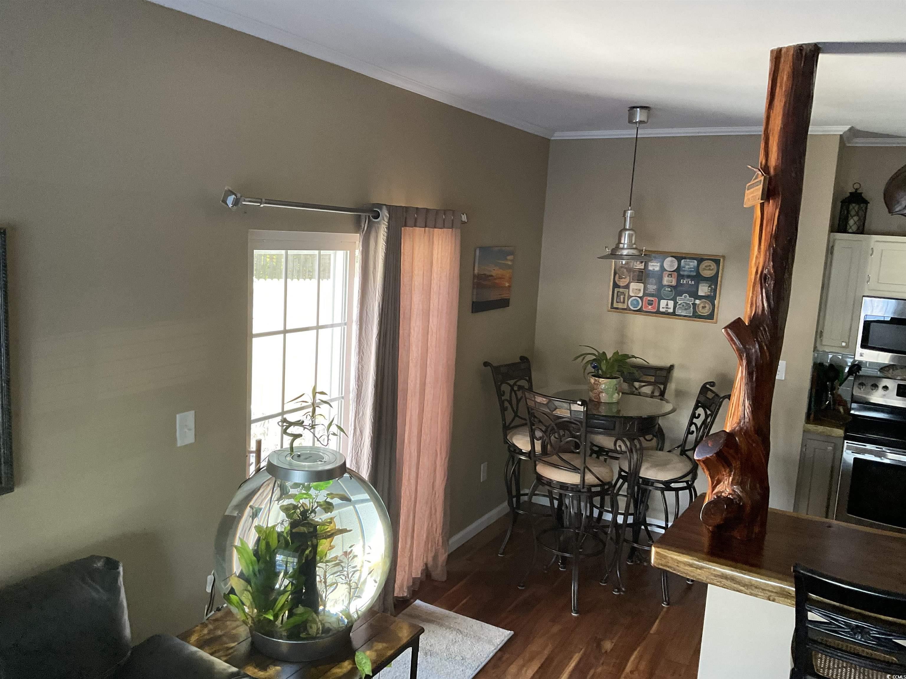 804 Brenda Place Myrtle Beach, SC 29577 - Photo 9 of 39 Dining space featuring dark wood-style floors and crown molding