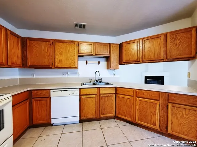 a kitchen with stainless steel appliances granite countertop a sink window and cabinets