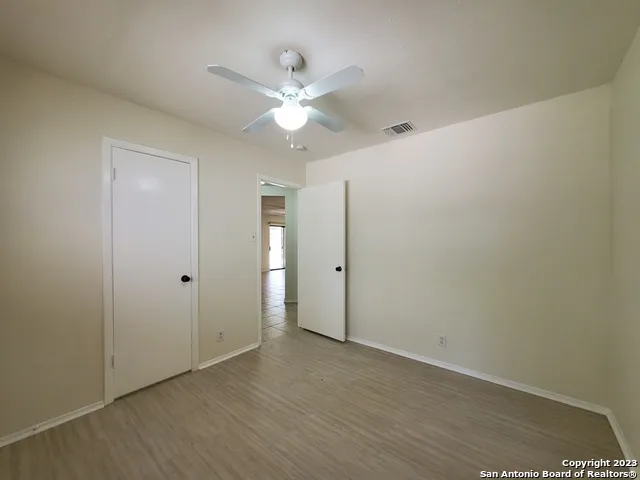a view of an empty room with wooden floor