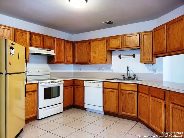 a kitchen with stainless steel appliances granite countertop wooden cabinets a sink and a stove