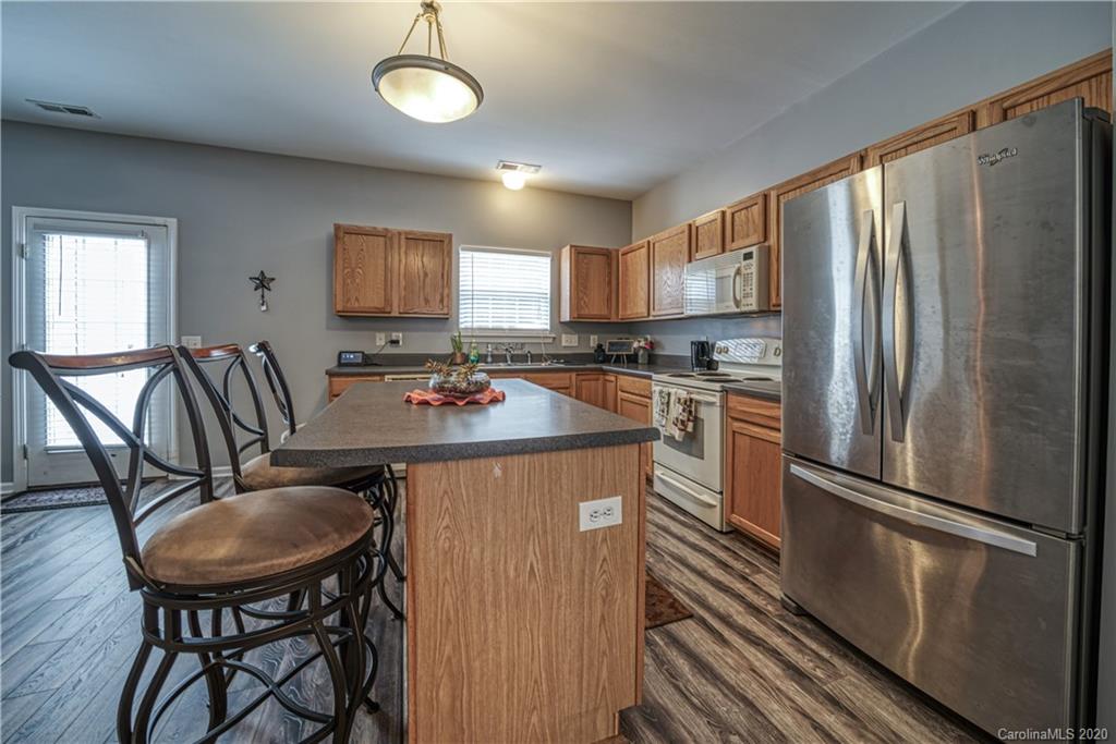 808 Dillard Road Rock Hill, SC 29730 - Photo 12 of 29 a kitchen with stainless steel appliances granite countertop a refrigerator a stove a sink a dining table and chairs with wooden floor