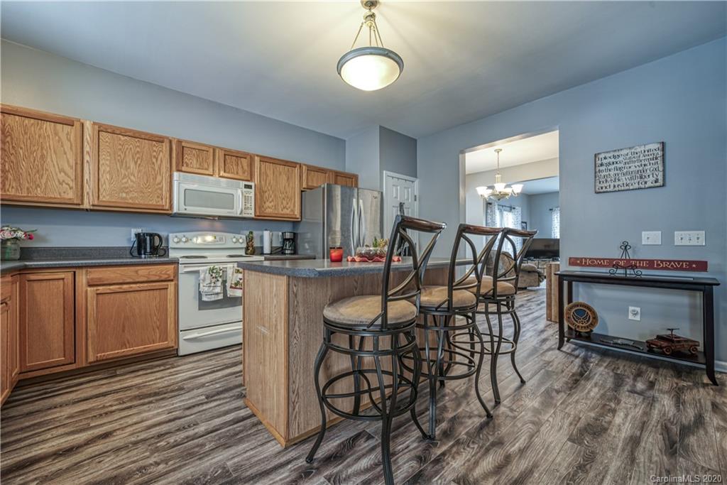 808 Dillard Road Rock Hill, SC 29730 - Photo 15 of 29 a kitchen with granite countertop a table chairs stove and cabinets