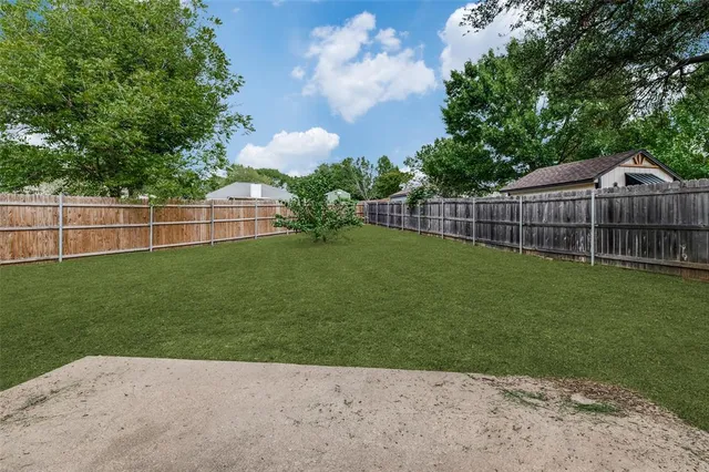 a view of a green yard with a small cabin