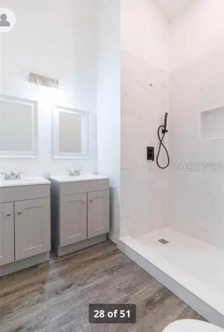 a spacious bathroom with a granite countertop sink a mirror and a bathtub