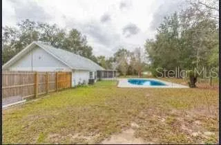 a view of a house with backyard and trees