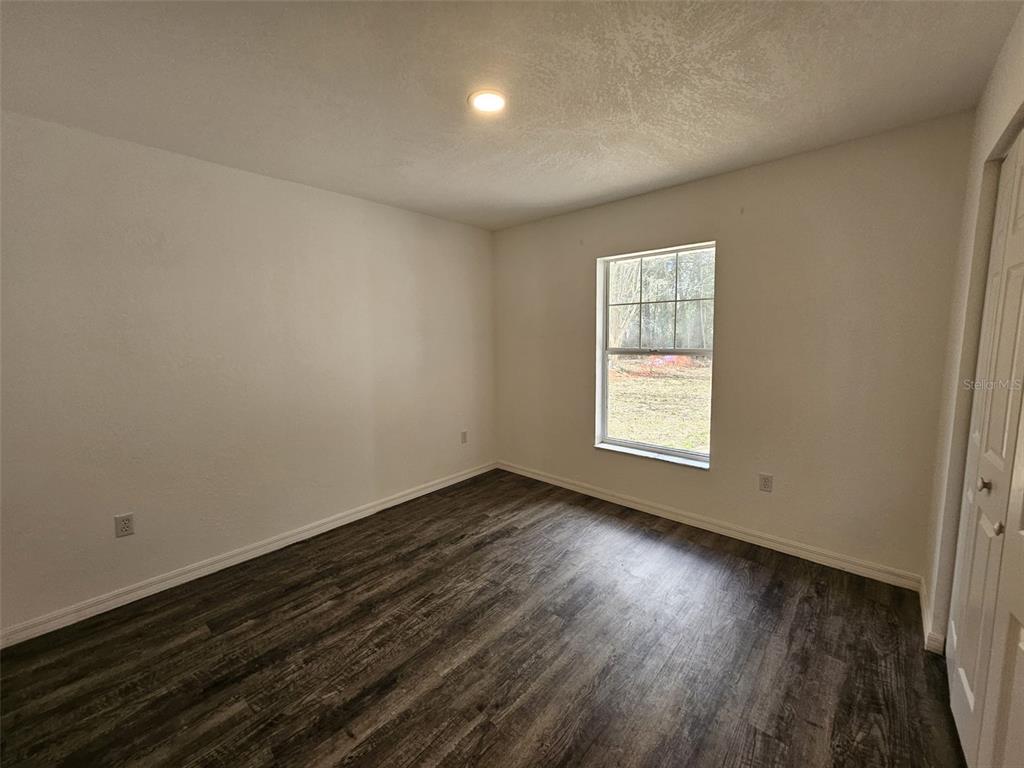 4 Cedar Trace Way Ocala, FL 34472 - Photo 28 of 36 an empty room with wooden floor and windows