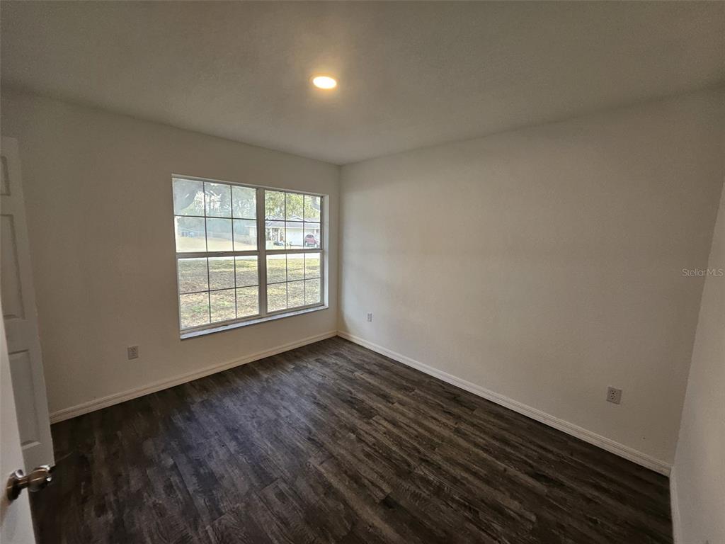4 Cedar Trace Way Ocala, FL 34472 - Photo 31 of 36 an empty room with wooden floor and windows