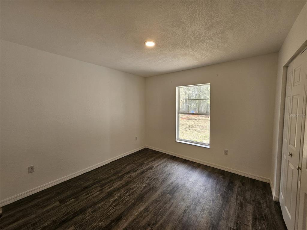 4 Cedar Trace Way Ocala, FL 34472 - Photo 32 of 36 a view of an empty room with wooden floor and a window