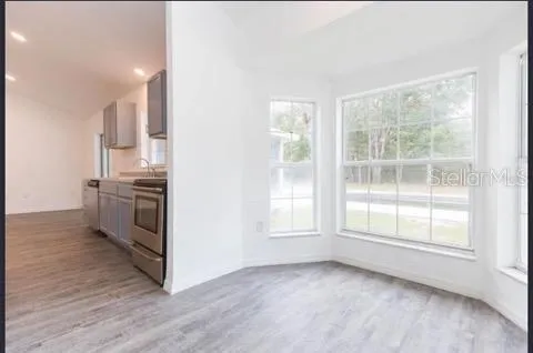 a view of a kitchen with wooden floor and electronic appliances
