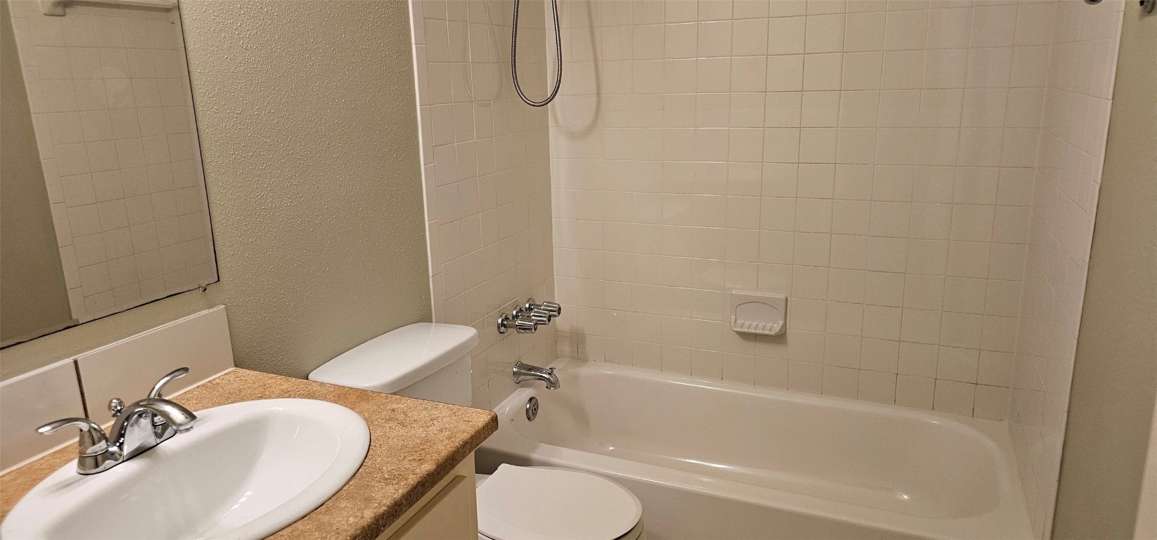 1411 Braes Ridge Drive, Unit B Austin, TX 78723 - Photo 21 of 37 a bathroom with a granite countertop sink toilet and shower