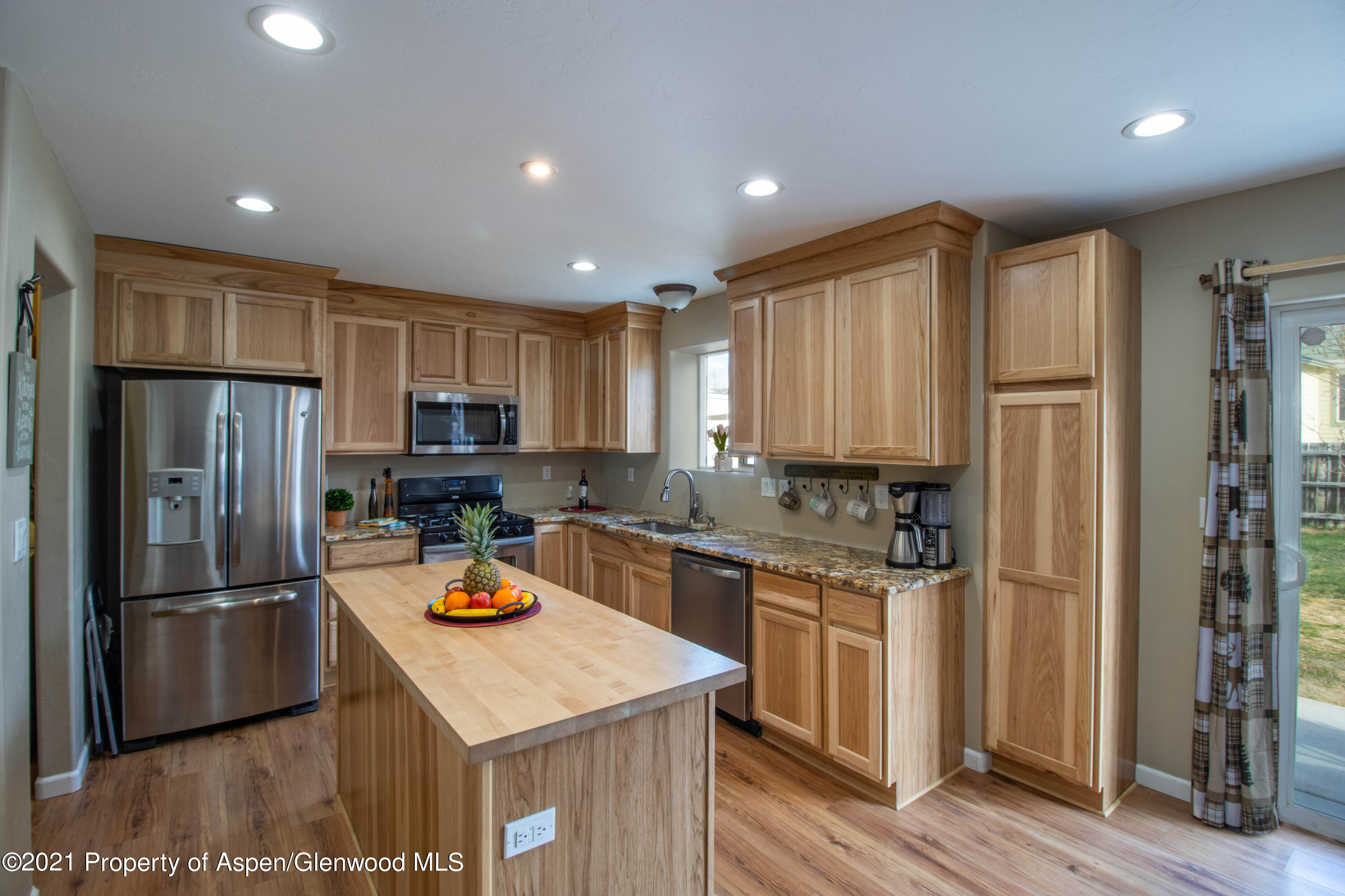 1280 East 18th Way Rifle, CO 81650 - Photo 3 of 18 a kitchen with a refrigerator a stove top oven and wooden floor