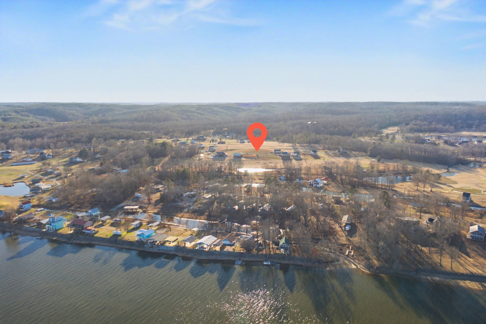 an aerial view of residential houses with outdoor space and lake view
