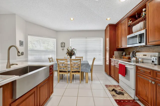 a kitchen with stainless steel appliances granite countertop a refrigerator and a stove top oven