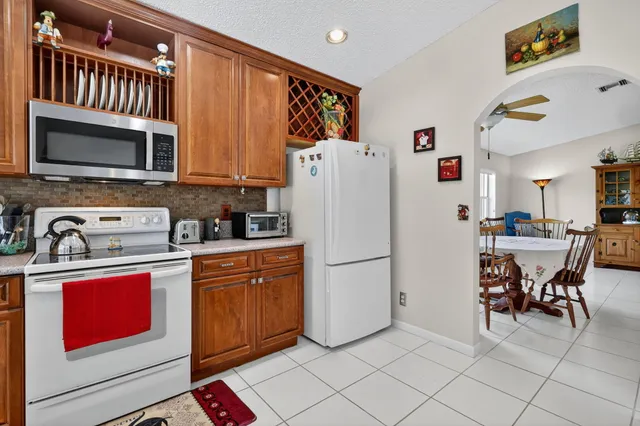 a view of kitchen with sink refrigerator and cabinets
