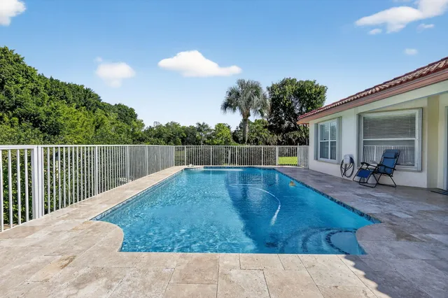 a view of a house with swimming pool and sitting area