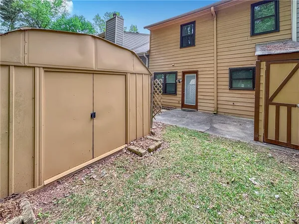 a view of a small house with backyard