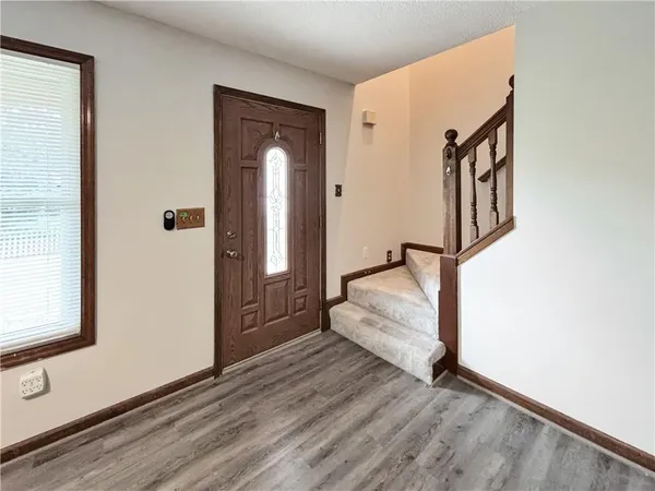 a view of a hallway with wooden floor and staircase