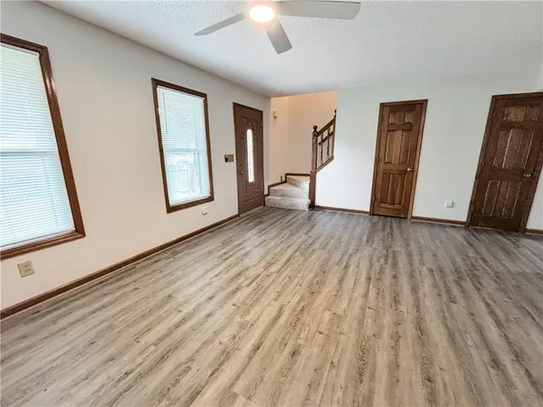 a view of an empty room with closet and a window