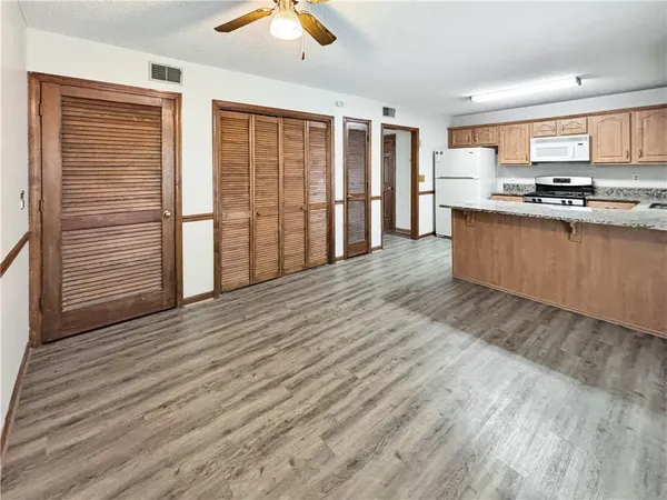 a large kitchen with stainless steel appliances wooden floors and wooden cabinets