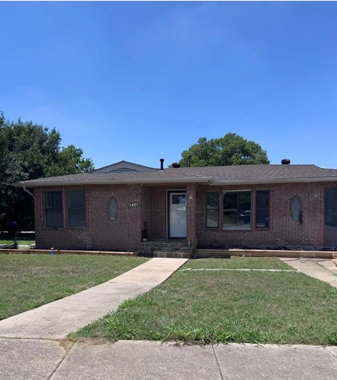 Brick exterior residence featuring a front entrance with a white door, framed by two oval windows with decorative grilles, and additional rectangular windows.