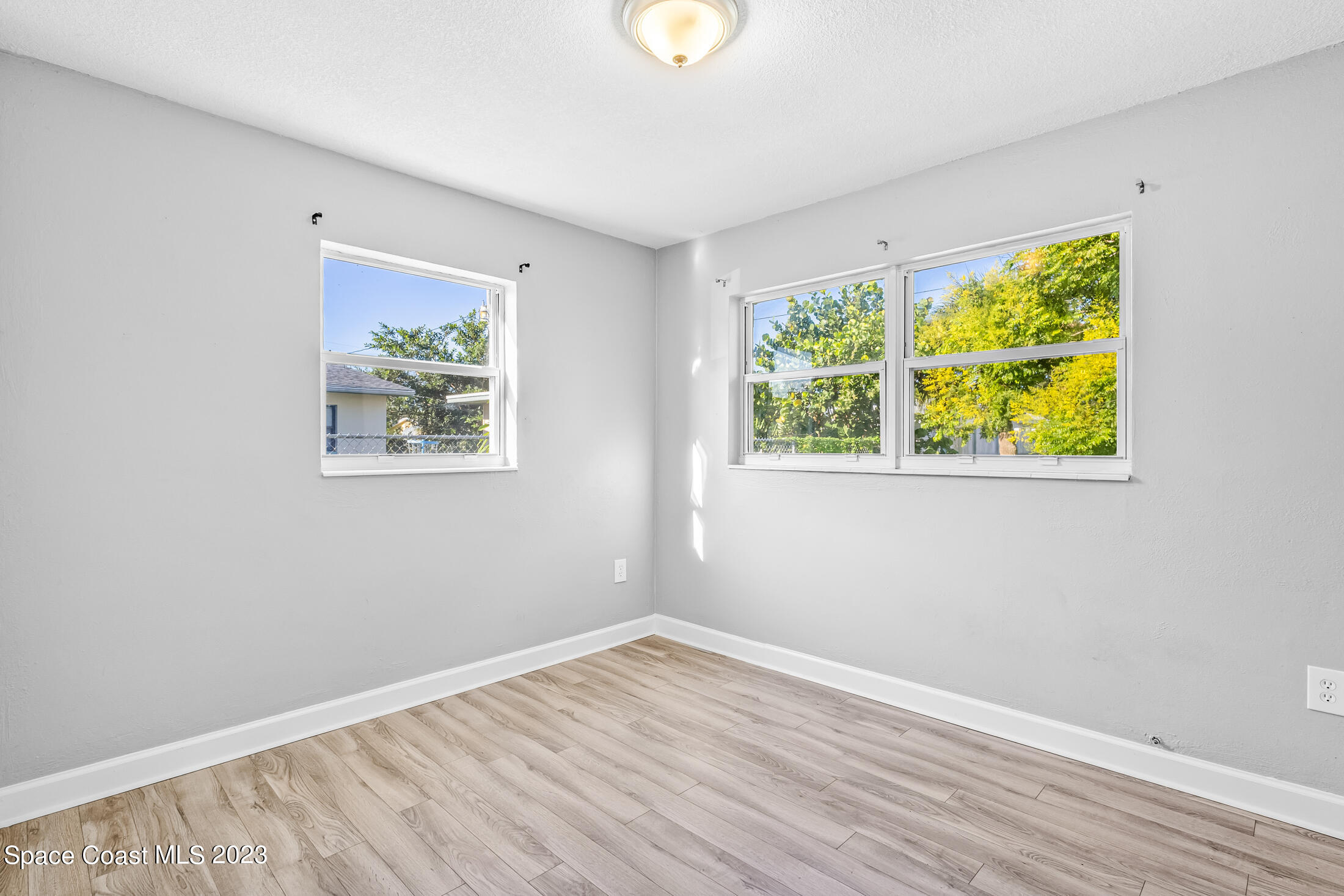 696 Teak Drive Melbourne, FL 32935 - Photo 16 of 22 a view of an empty room with wooden floor and a window