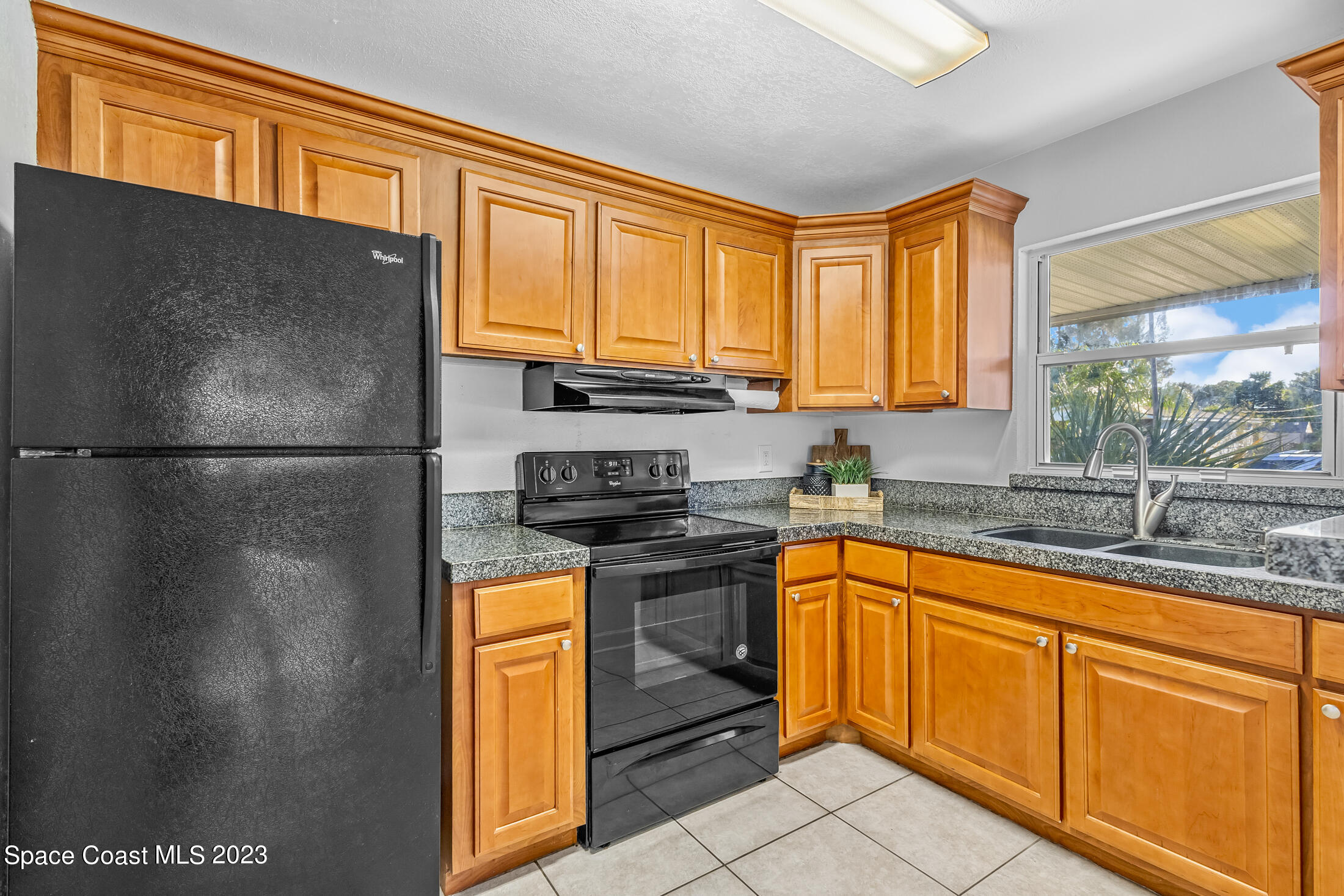 696 Teak Drive Melbourne, FL 32935 - Photo 20 of 22 a kitchen with stainless steel appliances granite countertop a refrigerator a sink dishwasher a stove and a refrigerator with wooden floor