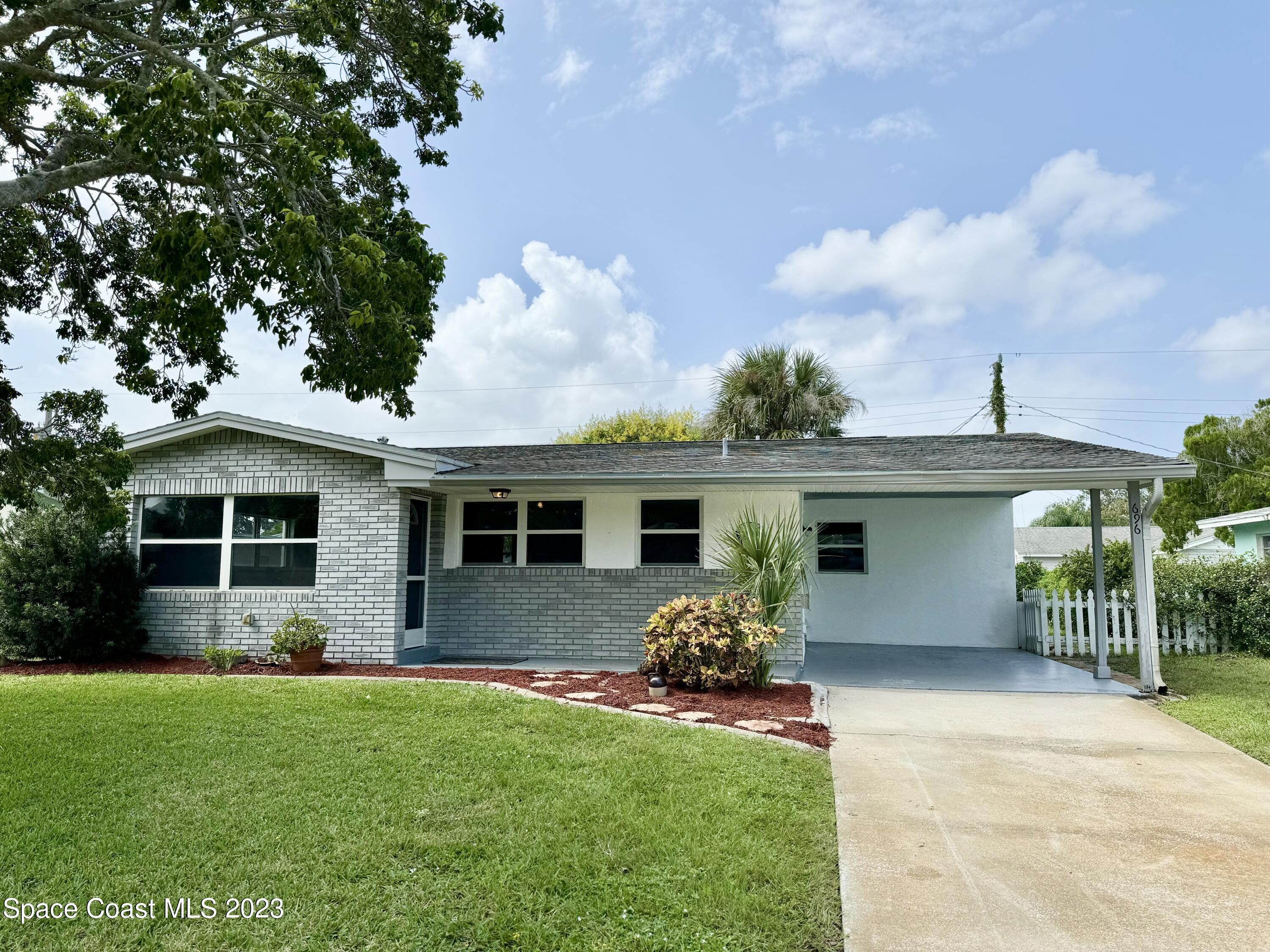 696 Teak Drive Melbourne, FL 32935 - Photo 2 of 22 a front view of house with yard and outdoor seating