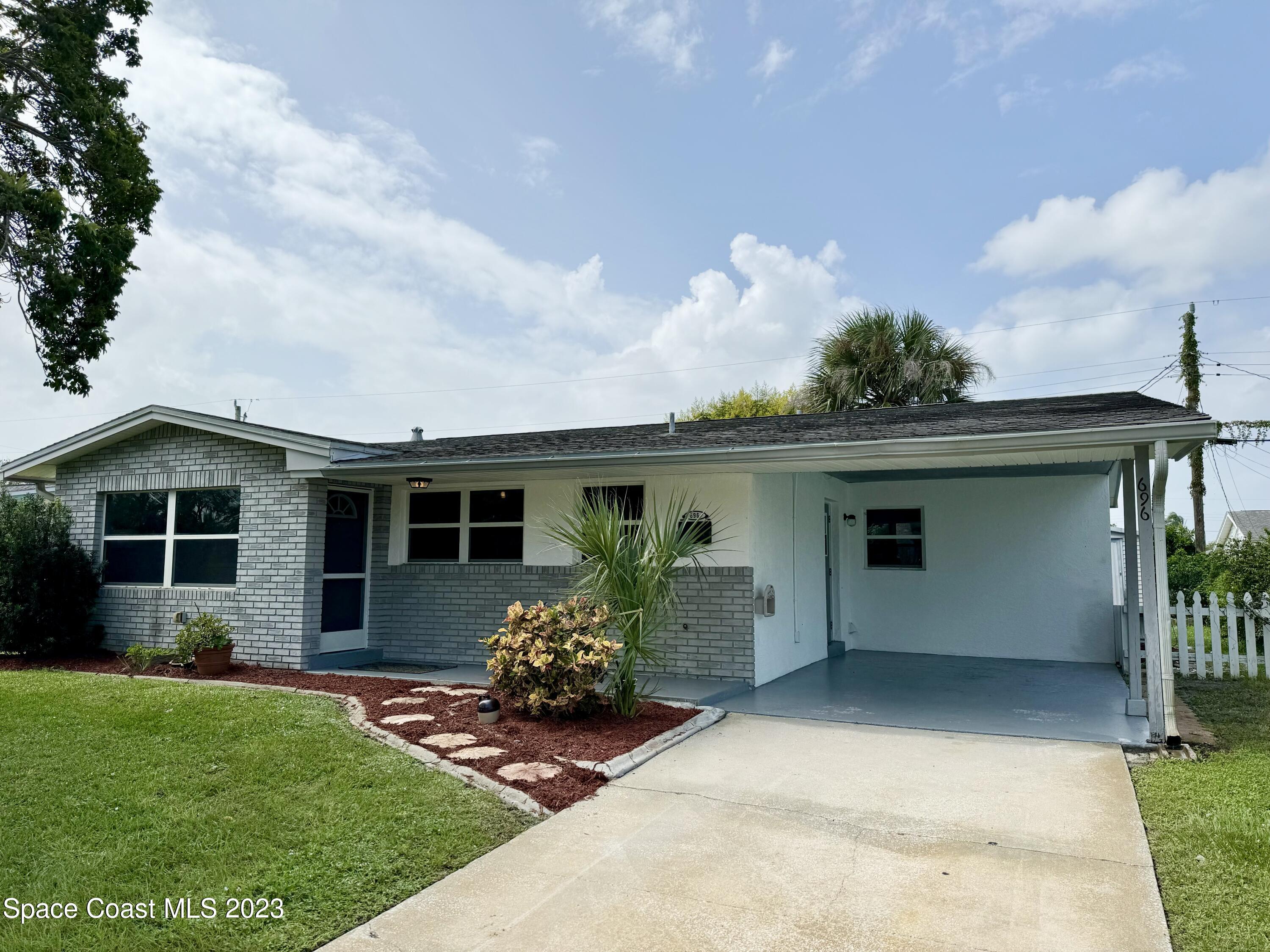 696 Teak Drive Melbourne, FL 32935 - Photo 3 of 22 a view of a house with a yard and a garden