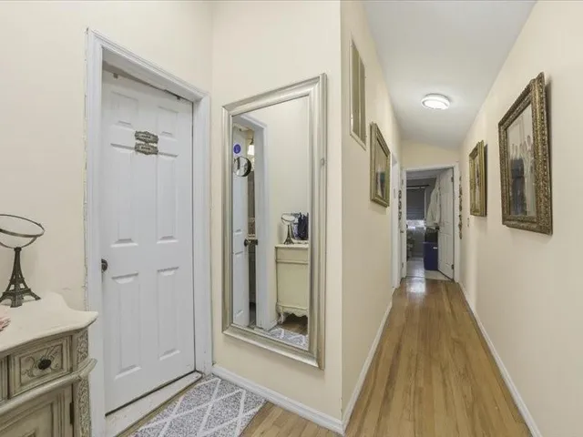 a view of a hallway with wooden floor and staircase